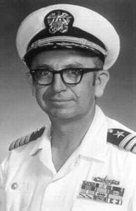 A man in a white uniform and glasses.