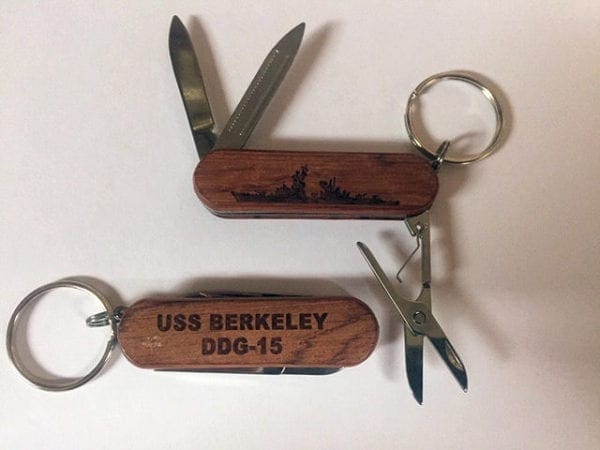 Two wooden key chains with a picture of the uss berkeley.