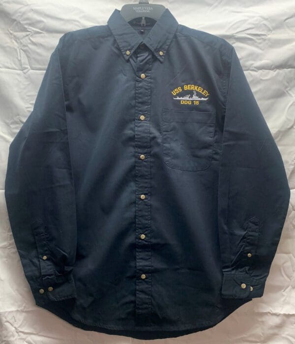 A Long Sleve Button Down Twill Shirt with Pocket and USS Berkeley Logo (Navy Blue) with an embroidered crest.